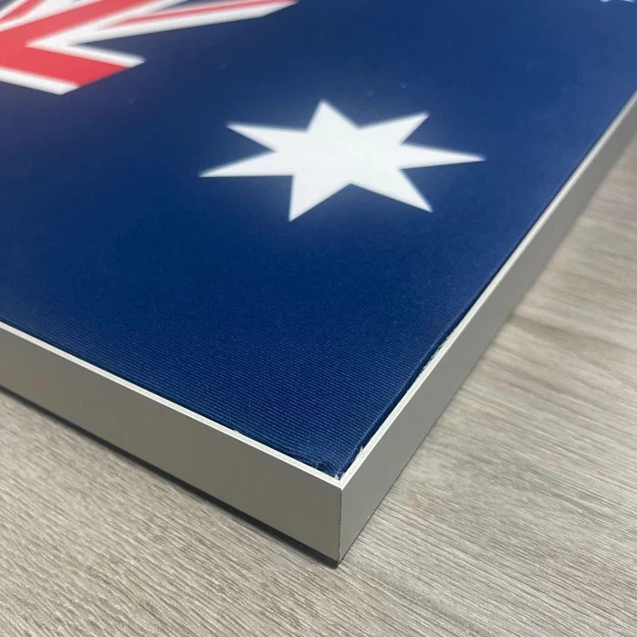 Close-up of the frame corner with the fabric print tensioned flush to the aluminium edge