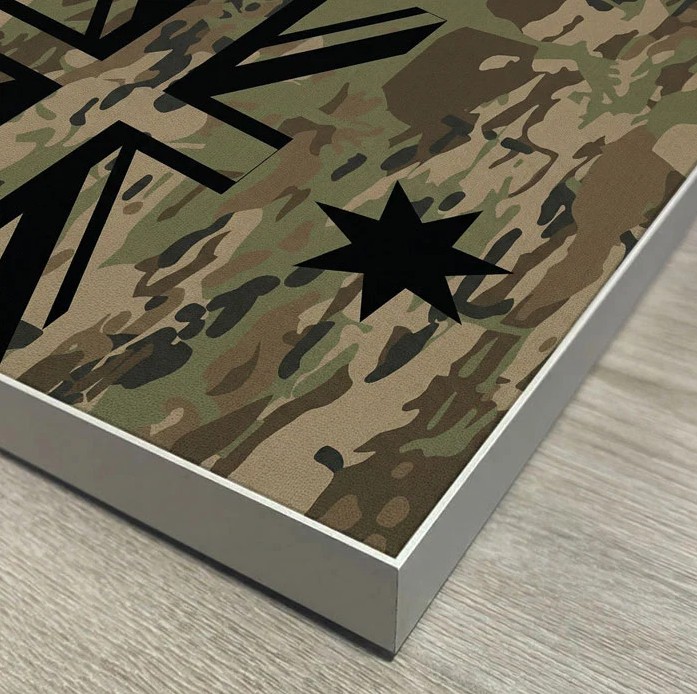 Close-up of a camouflage fabric print seated in the silver aluminium frame channel